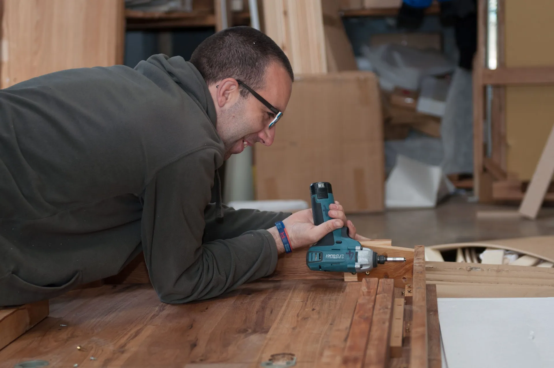 A team member fixing battens to a reclaimed oak table top in our workshop