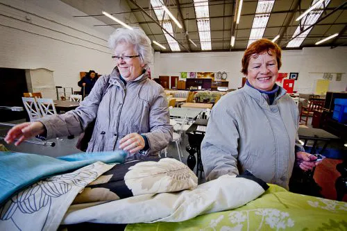 Two people choosing upholstery fabric together in a Doncaster Refurnish shop