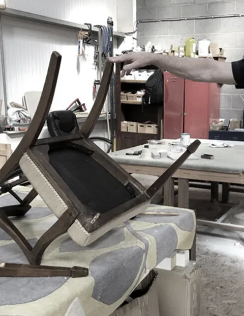 A chair part-way through repair on a workshop bench