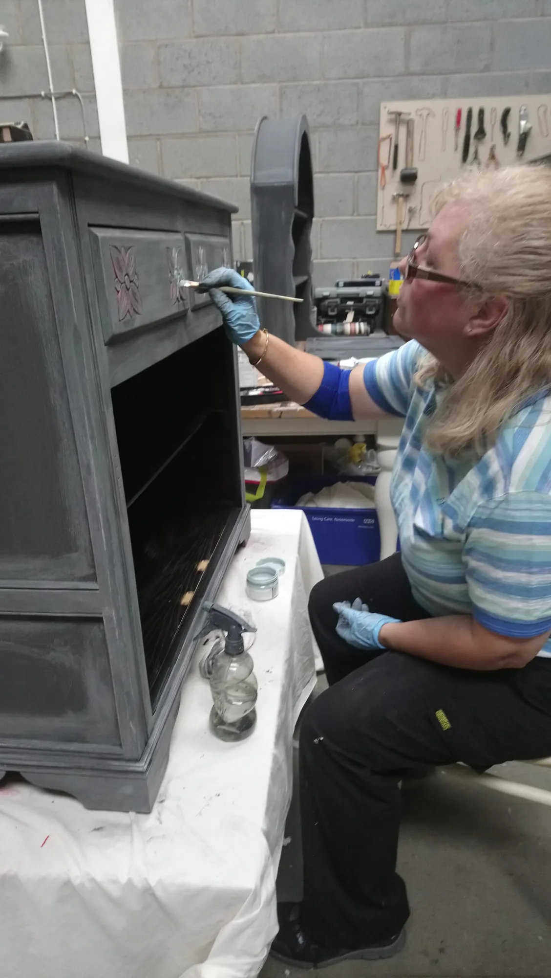 Close detail of a cabinet being hand-painted during restoration